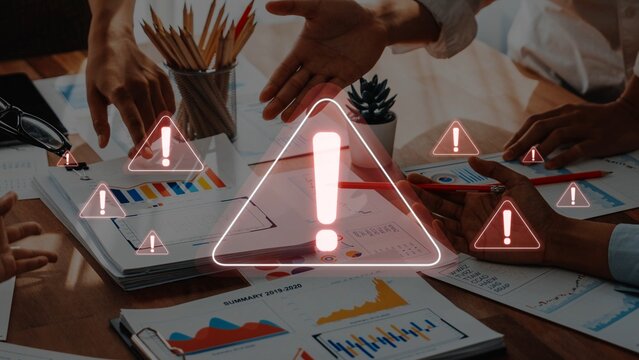 A diverse team collaborates over important project documentation in a modern office, emphasizing urgent decision-making with visual warnings and data insights. Raster