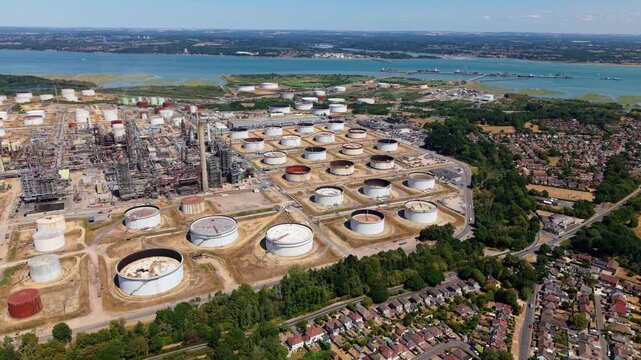 Aerial view of massive oil refinery with storage tanks, pipework, and exhaust stacks in Fawley UK
