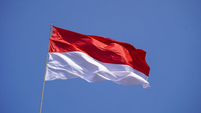 Indonesian flag red and white fluttering high against a bright blue sky for the 81st Independence Day.