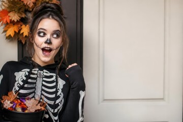 Fototapeta premium Young woman in skeleton hoodie with skull face paint