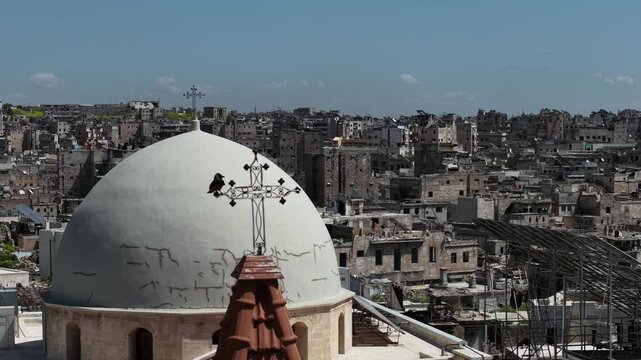 Aerial drone view of a church and Christian worshipers gathering in Syria. Weekly prayers and religious minorities in the Middle East. Golden dome and religious architecture.