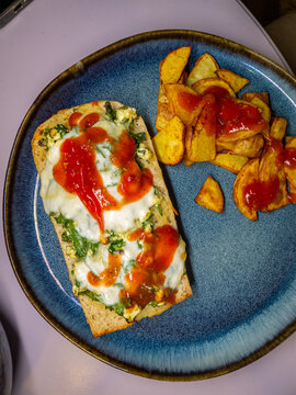Toasted Bread with Melted Cheese Spinach and Roasted Potato Wedges on Blue Plate