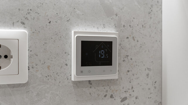 white sockets and thermostat for underfloor heating in the bathroom on tiles. electricity, technology. stylish designer expensive renovation