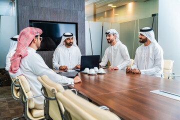 Fototapeta premium Group of corporate arab businessmen meeting in the office - Saudi and emirati business men meet for a business deal 