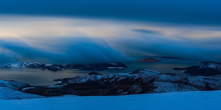 Panoramic winter scenery of Yamdrok Lake surrounded by snow-covered mountains after fresh snowfall in Tibet Autonomous Region, China. The vivid turquoise-blue waters contrast beautifully with the whit
