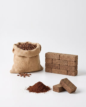 Coffee grounds transformed into sustainable building material on a white background.
