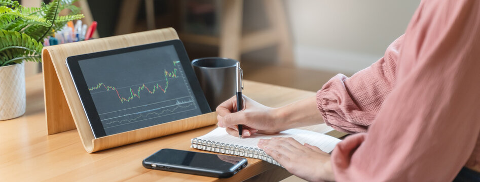 stock trade at home.  Close up hand of person learning and analyzing the chart of stock market via application