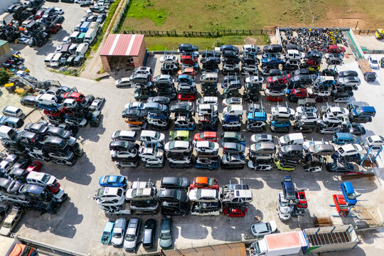 Aerial view of stacked cars and auto parts at an outdoor junkyard