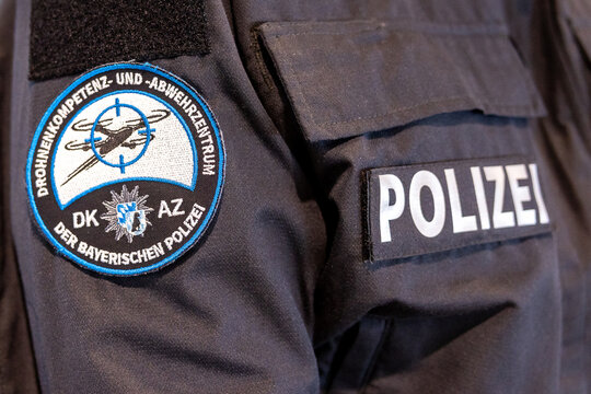 &Auml;rmelabzeichen des Drohnenkompetenz- und -abwehrzentrums (DKAZ) der Bayerischen Polizei auf einer Polizeiuniform, daneben der Schriftzug POLIZEI. 
