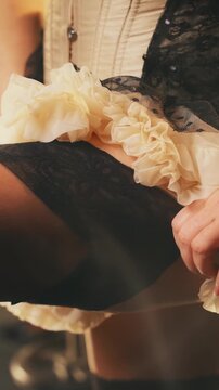 close-up hand retro lady puts on stockings on legs, short beauty dress. silhouette body part sexy woman cropped face burlesque show dancer. flapper girl 20s roaring twenties old style vertical video.
