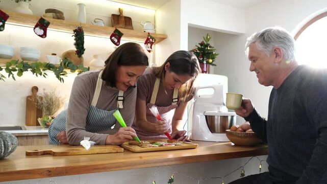 The family&mdash;parents and daughter&mdash;daughter and mother activities together, decorating gingerbread cookies with cream cheese and preparing food for a Thanksgiving