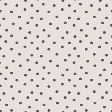 Soft beige background with scattered dark grey polka dots in a simple seamless pattern