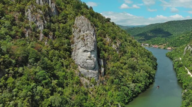 Aerial view of stone carved statue portrait of ancient dacian king Decebal. Sculpture located on shore of Danube River, Romania, 4k
