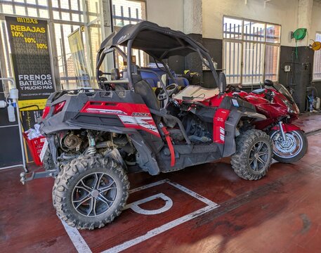 Vista lateral de un veh&iacute;culo todoterreno compacto con tracci&oacute;n en las cuatro ruedas CFMOTO ZForce , estacionado en un taller mec&aacute;nico de Madrid, 4 de junio de 2026