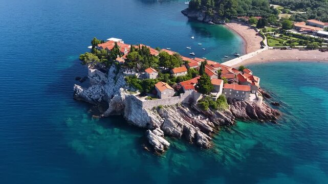Aerial view of the island of St. Stefan on the Adriatic coast of Montenegro in Mediterranean Sea, showing the coastline and architecture. It is an island resort and popular summer vacation destination