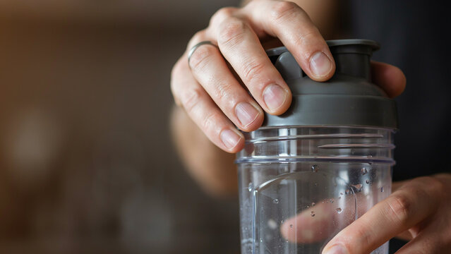 Close up of hand closing shaker bottle lid for protein drink