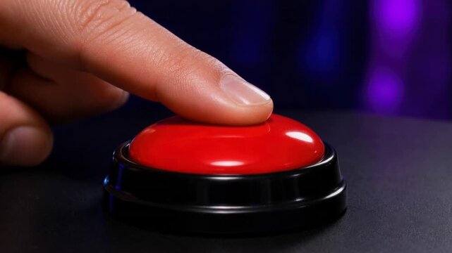 Close up of finger pressing a red button on black surface with blurred background for decision or alert concept