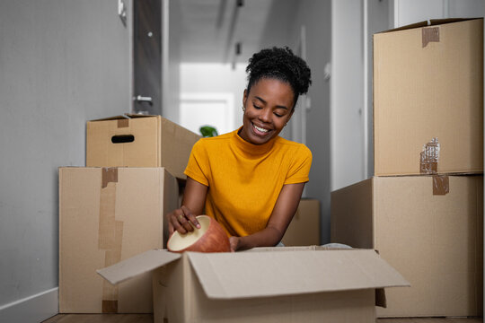 Woman unpacking boxes in a hallway of her new home during a moving process
