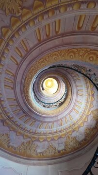 Baroque spiral staircase from a frog&rsquo;s-eye view, spiralling around the center of the frame.