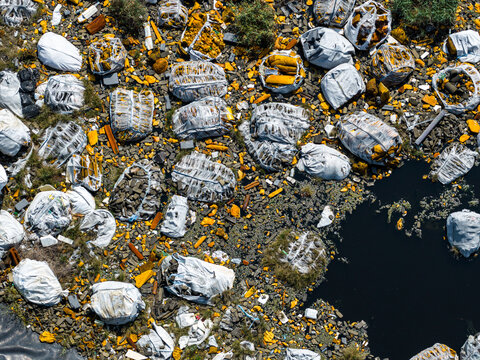 Wloclawek, Kujawsko-Pomorskie, Poland - 10 August 2026: Aerial view of large white industrial bags filled with yellow and dark materials stored at the ORLEN PTA plant site.