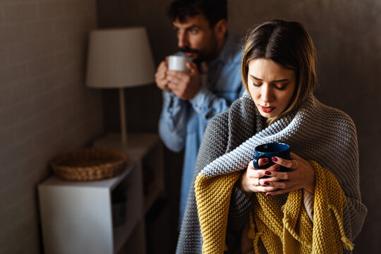 Freezing man and woman suffering from cold or flu fever or having trouble with central heating