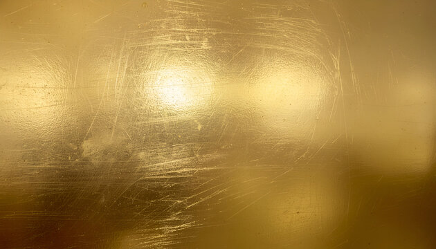 A close-up image showcases a textured gold surface with subtle scratches and highlights, creating an abstract and luxurious visual effect.