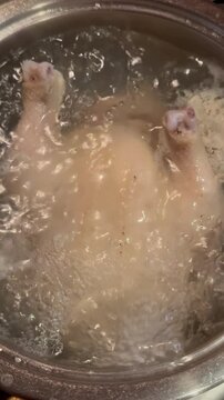 The chicken is cooking in boiling water.