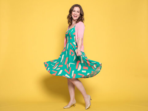 white woman dancing on yellow studio background 