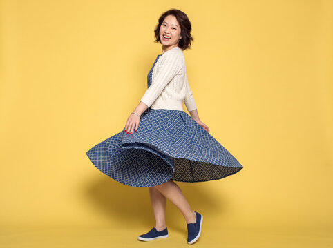 young asian woman in yellow background.
