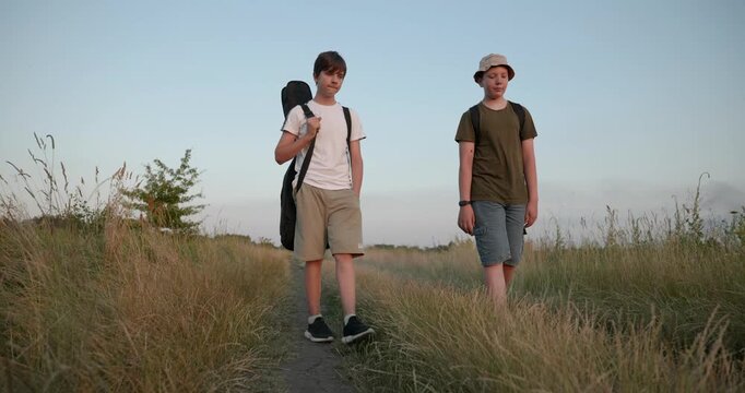Two friends boys hike walking on nature. Teenagers spending time together. 4K 10-bit