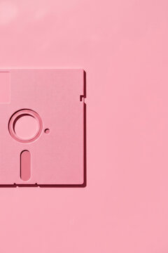 Pink floppy disk on a matching pink background