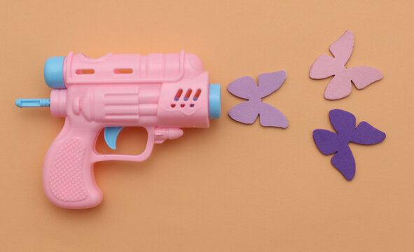 Toy gun and butterflies. No war, peace concept.