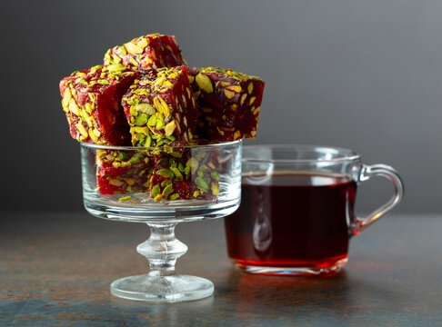 Turkish delights with black tea on a dark  background.