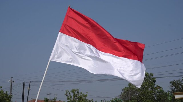 Indonesian red and white national flag waving proudly against a clear blue sky, perfectly capturing the vibrant spirit and patriotic pride for Indonesia's 81st Independence Day anniversary celebration