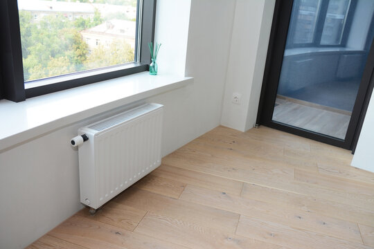 Interior apartment with wooden floor balcony door radiator window