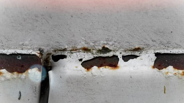 Seamless 4K looping vertical movement over a painted metal surface with rusted crack and aged industrial texture. Suitable for grunge backgrounds construction visuals and motion design.