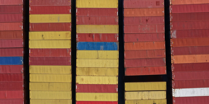 Miami, Florida, United States - 07 February 2026: Aerial view of colorful shipping containers stacked in rows at the Port of Miami, showing geometric patterns of red, yellow, and blue.