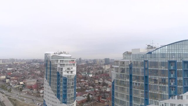 Aerial view of Krasnodar cityscape  showcasing modern high-rise buildings and urban landscape under a cloudy sky.