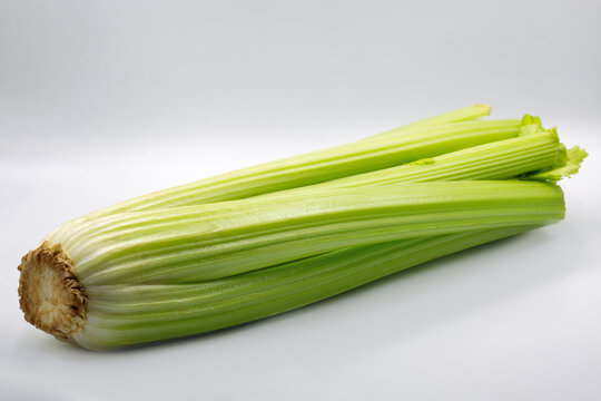 Fresh green celery stalk bunch on white background, closeup.