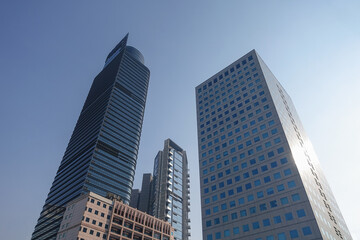 Naklejka premium Modern office buildings forming a contemporary Jakarta business district skyline under a clear blue sky, representing urban architecture, corporate business, real estate and economic development