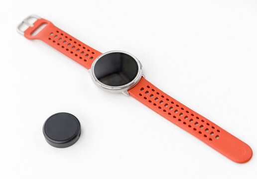 Modern Round Smartwatch with Orange Perforated Sport Strap and Charger