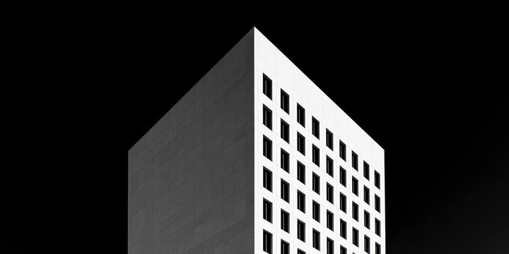 Modern high-rise building with geometric facade against dark sky