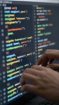 person hands typing computer keyboard computer screen filled multiple code snippets different colors sizes code snippets appear related programming coding background blurred seems like person focused