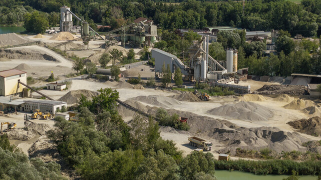 Gundelfingen an der Donau, Germany - 23 July 2026: Aerial view of the Fetzer GmbH Co. KG gravel plant with industrial machinery, piles of sand, conveyor belts, and surrounding greenery.