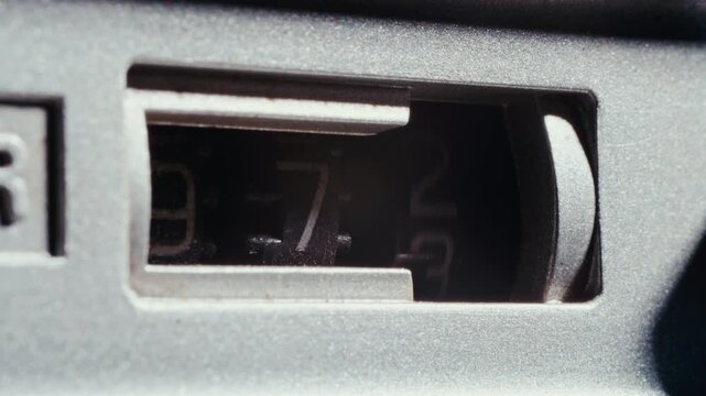 Three-digit mechanical analog tape counter with rotating wheels on vintage cassette recorder deck. Detailed macro shot