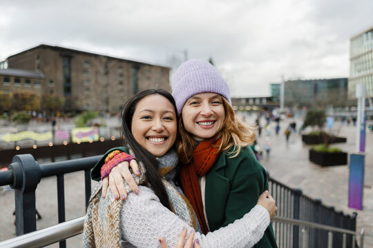Smiling women friends bonding in city market