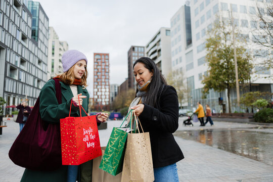 Two friends enjoying christmas shopping in city