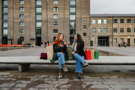Friends talking after Christmas shopping in Granary Square, London