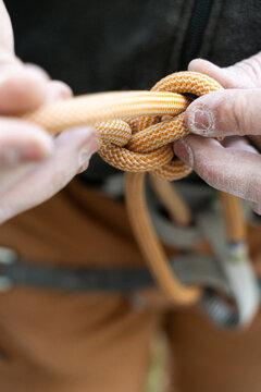 Hands Tie a Knot With Climbing Rope During an Outdoor Activity