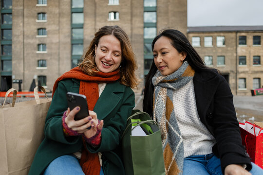 Diverse women friends shopping looking at phone
